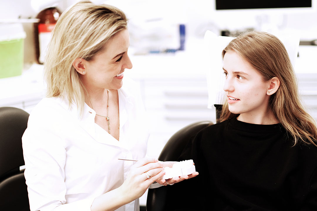 Frau Doktor Krieter erklärt einer Patientin etwas an einem Gebiss in der Zahnarztpraxis in Rregensburg