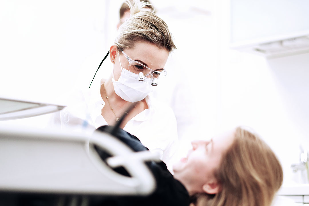 Frau Doktor Krieter lächelt freundlich eine Patientin an, die auf einem Behandlungsstuhl in der Praxis in Regensburg liegt